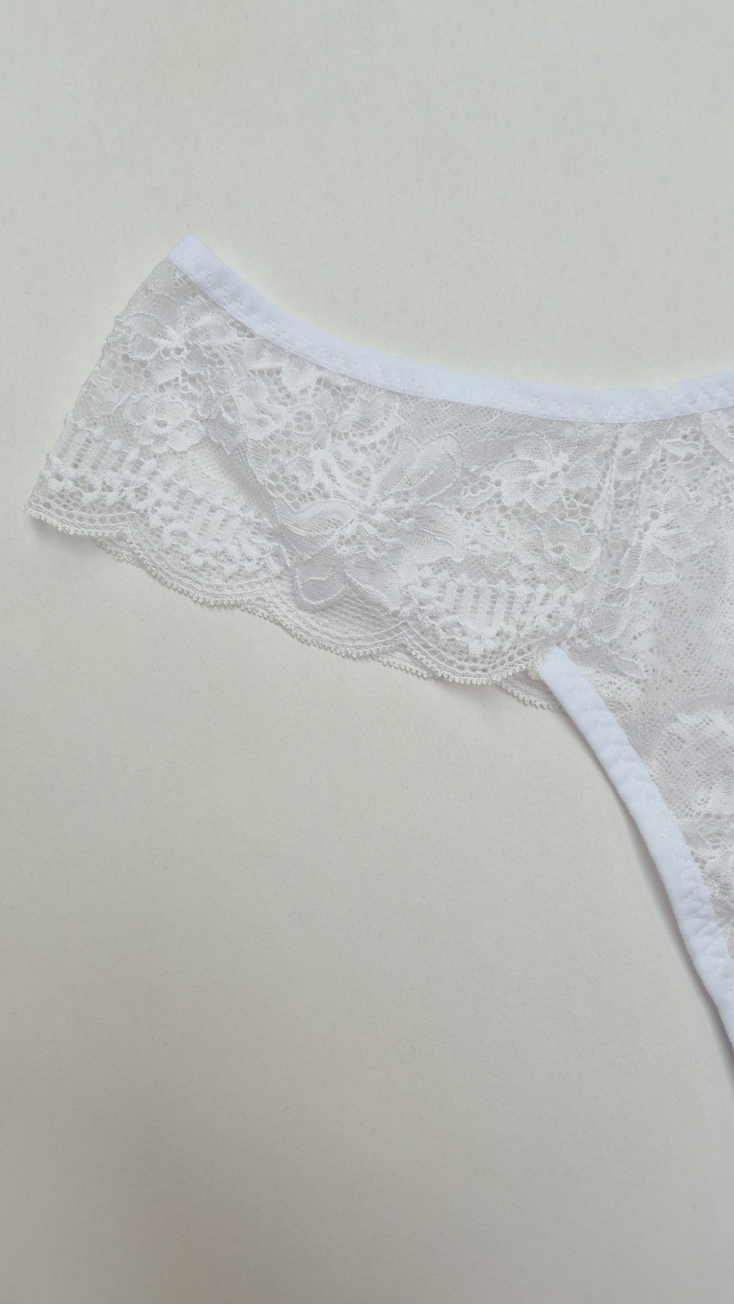 Calcinha Aurora branca toda em renda floral, modelagem confortável, cintura média e acabamento artesanal. Plaquinha personalizada naughty na cor dourada.