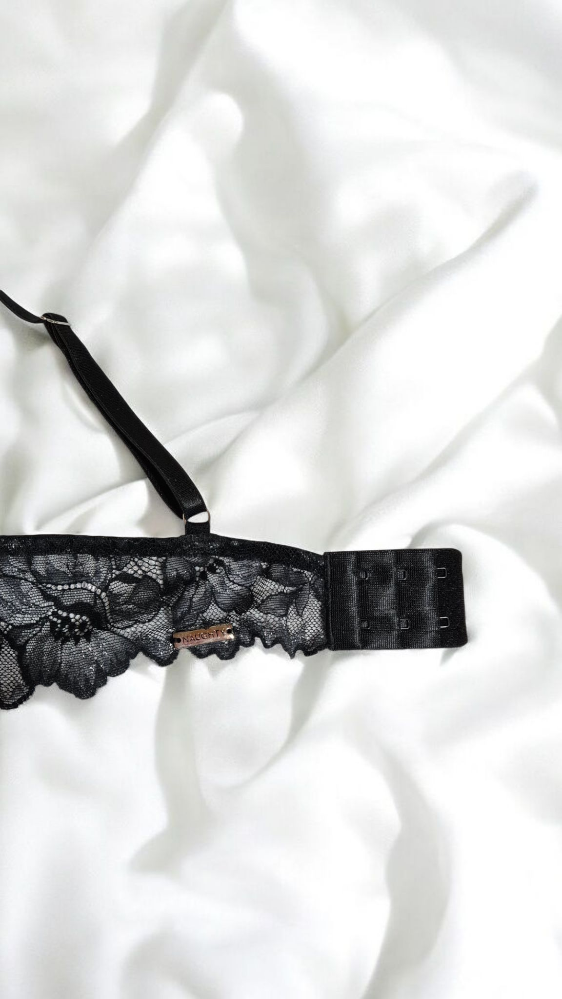 Bralette Shine preto com leve brilho prateado, forro em microfibra e modelagem confortável sem bojo e fecho reforçado. Plaquinha personalizada naughty na cor prata 