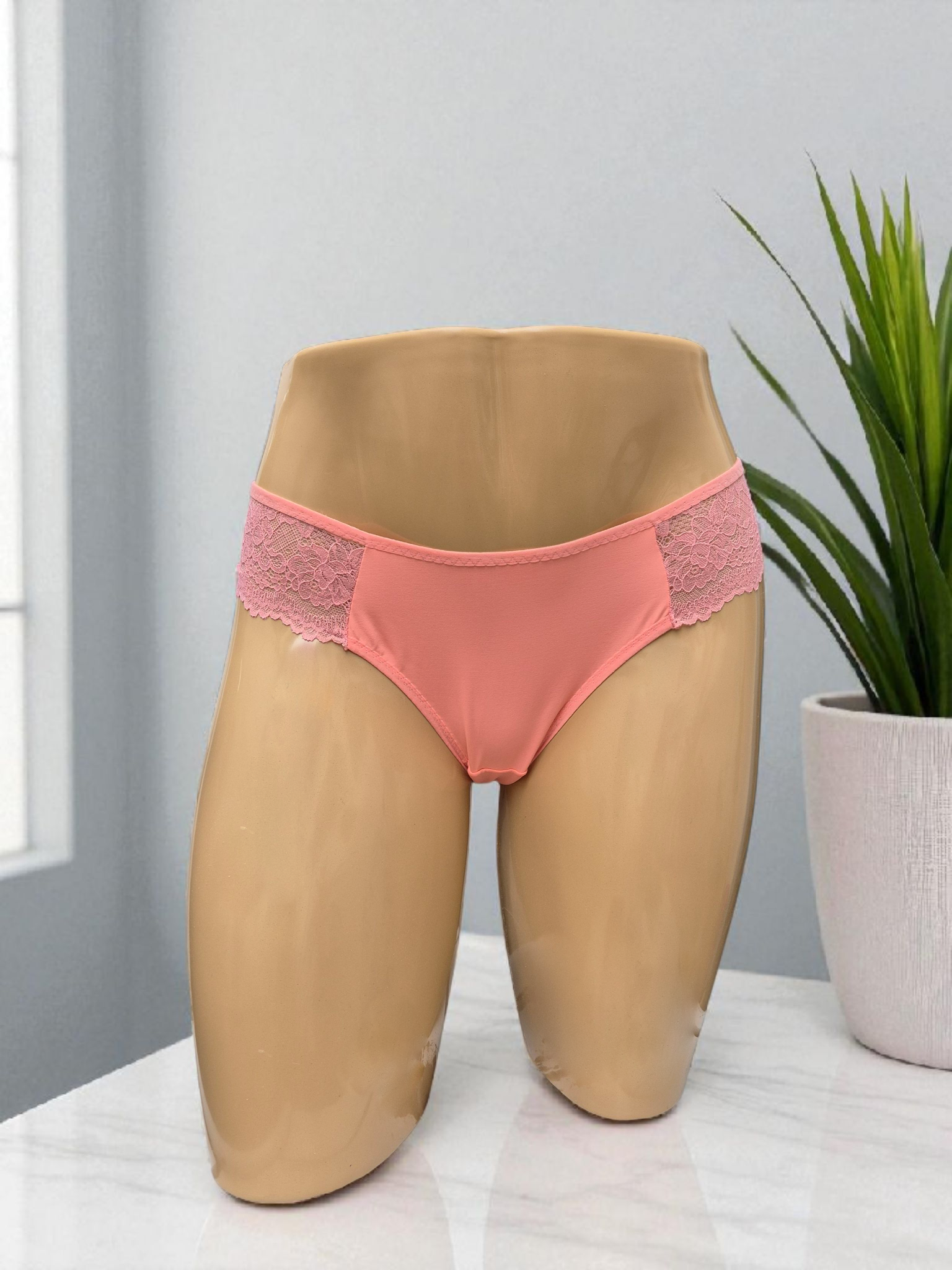 Calcinha Belle coral com laterais em renda delicada, cintura média, modelagem confortável e plaquinha dourada Naughty. Frente e costas em microfibra, forro 100% algodão. Peça artesanal