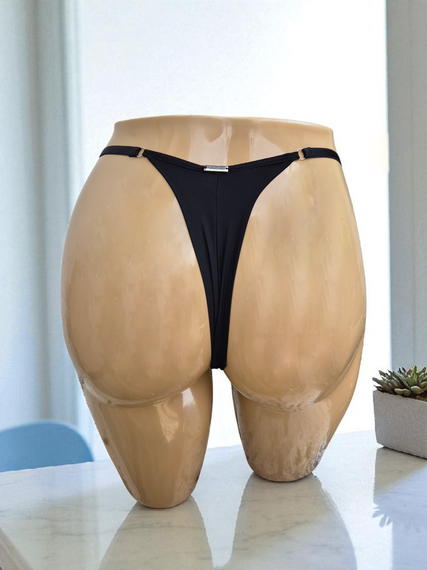 Calcinha string Seduce preta com detalhes em renda e flor bordô, alças ajustáveis e design sensual. Fio duplo em microfibra e plaquinha personalizada na cor prata. 