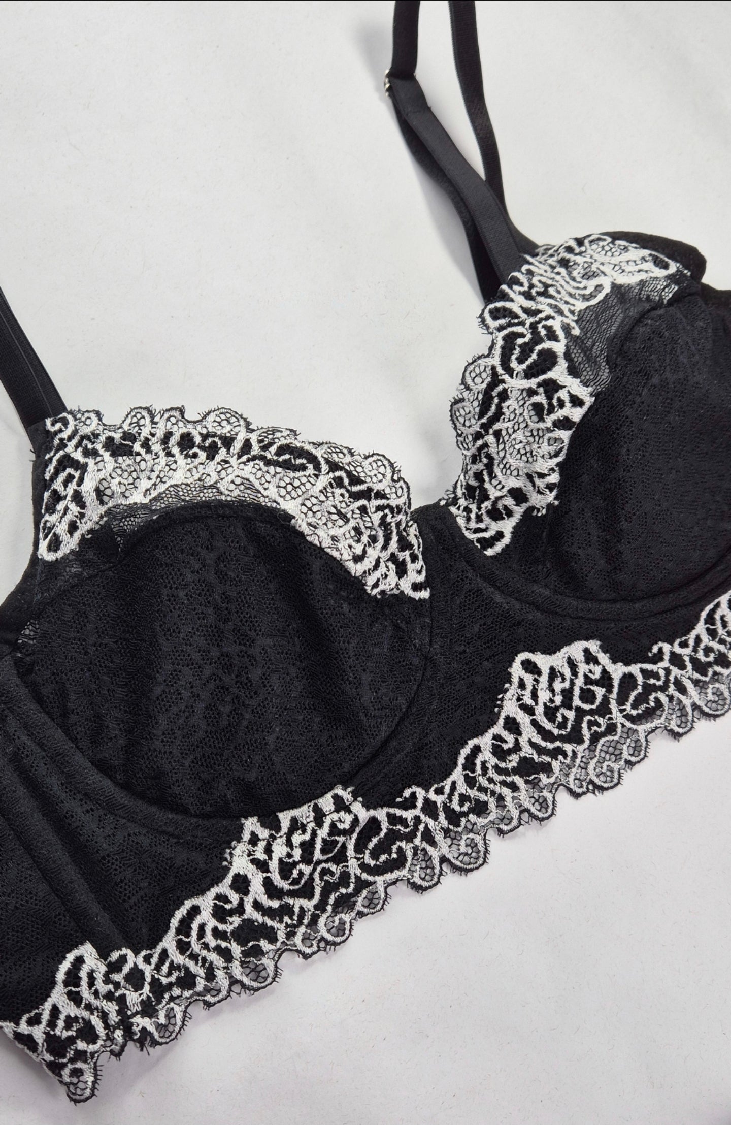 Sutiã Luxe preto e branco com renda delicada, sem bojo, com aro e reforço nas laterais, confortável e elegante. Forrado internamentos com tecido 100% algodão, fecho reforçado e plaquinha Naughty personalizada na cor prata. 